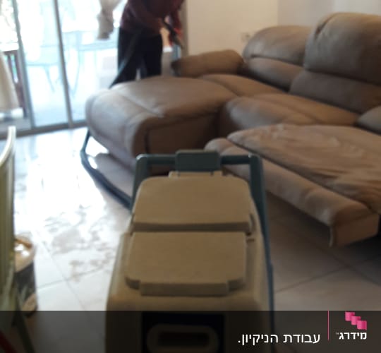 מכונת ניקוי שטיחים ואדם מנקה ספה